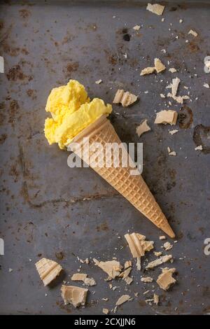 Hausgemachte Mango Eis Waffelhörnchen mit Wafer Krümel über rostiges Metall strukturierten Hintergrund. Ansicht von oben Stockfoto