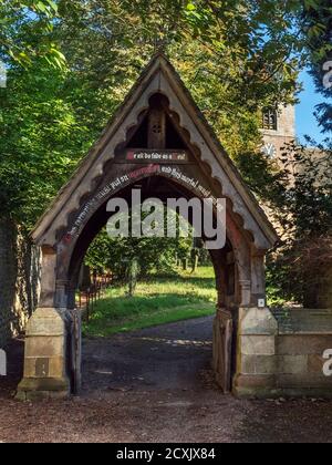 Lychgate trägt die Inschrift Wir alle verblassen als ein Blättern Sie an der Church of the Ascension Whixley in der Nähe von Knaresborough North Yorkshire England Stockfoto