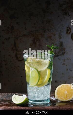 Hausgemachte Zitronen- und Limettenlimonade, serviert in Glas mit Eis und frischer Minze, oveer dunklen Eisen rostigen Hintergrund. Mit Platz für Text Stockfoto