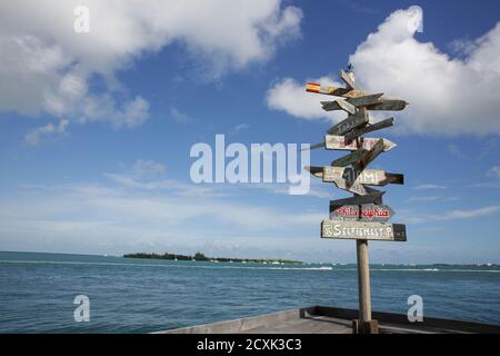 Beliebte Richtungen und Entfernungen [in Meilen] Schilder an der ebenso beliebten Sunset Pier Bar auf Key West, Florida, USA. Stockfoto