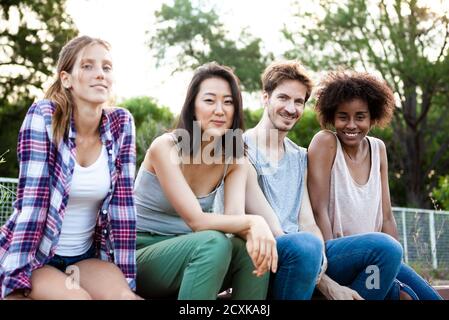 Gruppe junger Freunde, die zusammen im Park sitzen Stockfoto