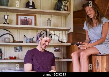 Junges Paar mit Smartphone im Wohnzimmer Stockfoto