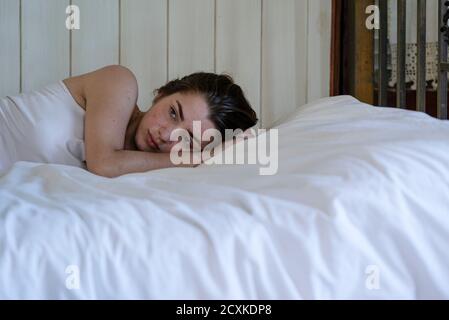 Junge Frau auf Bett liegend Stockfoto