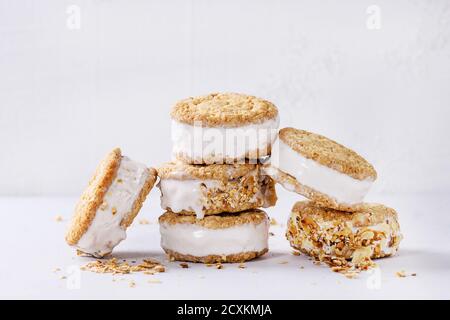 Satz von hausgemachtem Eis sandwiches in Hafer-Kekse mit Mandeln Zucker Krümel über graue Textur Hintergrund. Textfreiraum Stockfoto