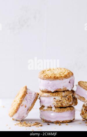 Satz von hausgemachtem Eis sandwiches in Hafer-Kekse mit Mandeln Zucker Krümel über graue Textur Hintergrund. Textfreiraum Stockfoto