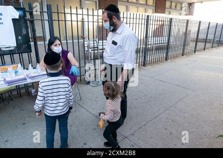 NYC versucht, auf Maskenverschleiß in Gebieten, wo Spitze in positiven Fällen in Brooklyn entdeckt zu knacken.Stadtbeamte besorgt über Spitzen in überwiegend jüdischen orthodoxen Gemeinden und begann, die zunehmende Zahl von positiven COVID-19 Fällen zu bekämpfen. Freiwillige und Stadtarbeiter aus verschiedenen Abteilungen, einschließlich Test und Trace Corpand City Health Hospitals verteilt Masken und Händedesinfektionsmittel. Viele weitere Menschen begannen, Masken zu tragen, doch einige weigern sich, dies auch im Innenbereich zu tun. (Foto von Lev Radin/Pacific Press) Stockfoto