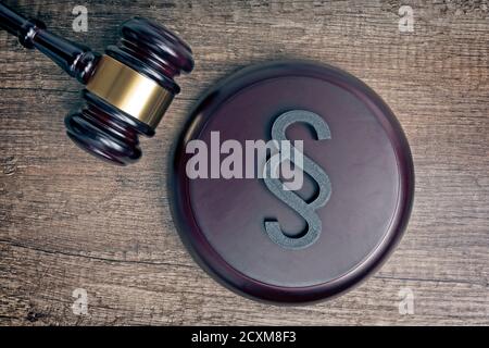 Hölzerner Richter Gavel neben einem Absatz / Abschnitt Zeichen als Symbol für die Idee von Justitia und Gesetz. Stockfoto