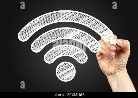 Wi-Fi-Zeichen. Doodle Zeichnung auf einer Tafel, geschrieben mit weißer Kreide in der Hand. Stockfoto