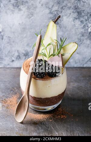 Dessert Frühstück geschichteten Chia-Samen, Schoko-Pudding, Reis Brei aus Glas dekoriert mit frischen Brombeeren, in Scheiben geschnitten Birne, Kakaopulver. Stehen mit Stockfoto