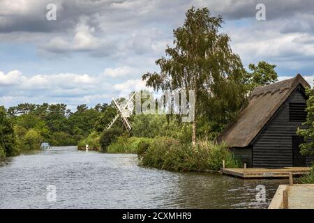 Bootshaus und Boardman's Drainage Mill am Fluss Ant auf den Norfolk Broads in How Hill, Ludham, Norfolk, England, Großbritannien. Stockfoto