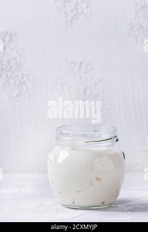 Weizen Starter Sauerteig in Gläsern zum Backen von hausgemachtem Brot auf grauem Beton Hintergrund. Stockfoto