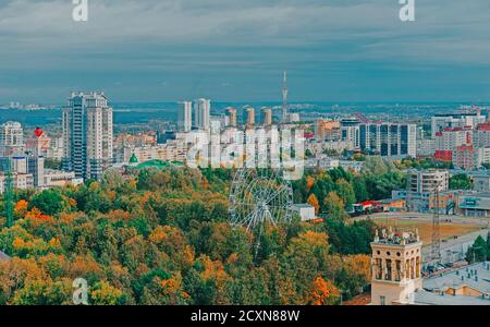 Blick auf den zentralen Park von Perm aus einer Höhe. Riesenrad zwischen grünen Bäumen. Skyline der Stadt. Stockfoto