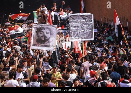 Bagdad, Irak. Oktober 2020. Irakische Demonstranten halten während eines Protestes auf dem Tahrir-Platz, zum ersten Jahrestag der regierungsfeindlichen Demonstrationen, Flaggen. Quelle: Ameer Al Mohammedaw/dpa/Alamy Live News Stockfoto