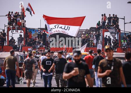 Bagdad, Irak. Oktober 2020. Irakische Demonstranten halten während eines Protestes auf dem Tahrir-Platz, zum ersten Jahrestag der regierungsfeindlichen Demonstrationen, Flaggen. Quelle: Ameer Al Mohammedaw/dpa/Alamy Live News Stockfoto