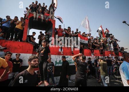 Bagdad, Irak. Oktober 2020. Irakische Demonstranten halten während eines Protestes auf dem Tahrir-Platz, zum ersten Jahrestag der regierungsfeindlichen Demonstrationen, Flaggen. Quelle: Ameer Al Mohammedaw/dpa/Alamy Live News Stockfoto