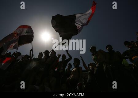 Bagdad, Irak. Oktober 2020. Irakische Demonstranten halten während eines Protestes auf dem Tahrir-Platz, zum ersten Jahrestag der regierungsfeindlichen Demonstrationen, Flaggen. Quelle: Ameer Al Mohammedaw/dpa/Alamy Live News Stockfoto