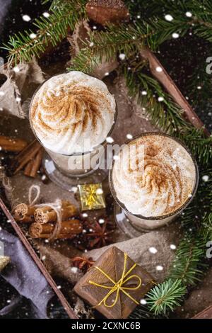 Kürbis würzig Latte mit Sahne und Zimt in zwei Gläser im Holzbrett mit Textil- und Dekoration und Tanne Weihnachtsbaum andere stehen Stockfoto