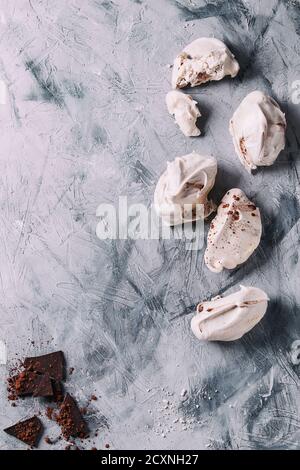 Backen hausgemachte französisch Dessert Baiser mit Schokolade serviert mit dunkler Schokolade und Kakao pulverover grauen Beton Textur Hintergrund. Oben Stockfoto
