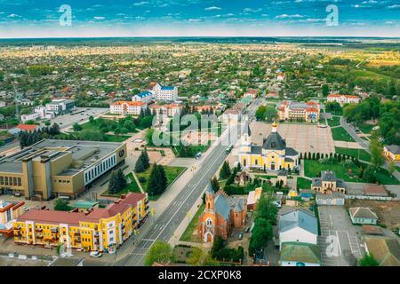 Rechyza, Weißrussland. Luftaufnahme Von Wohnhäusern Und Berühmten Sehenswürdigkeiten Der Stadt: Heilige Himmelfahrt Kathedrale Und Kirche Der Heiligen Dreifaltigkeit Im Sonnigen Sommer Stockfoto