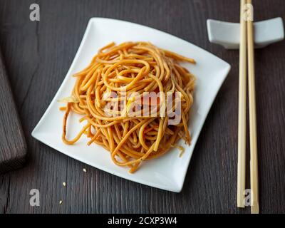 Teller gebratene Nudeln mit Gemüse auf Restauranttisch, chinesische Küche Stockfoto