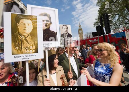 Der Londoner Marsch des Immortal Regiments, der marsch soll russischen Männern und Frauen gedenken, die im Zweiten Weltkrieg gekämpft haben und in Russland und anderen Ländern am 9. Mai im Rahmen der Feierlichkeiten zum Victory Day stattfinden. Während der Märsche tragen die Menschen Fotos ihrer Verwandten, die am Krieg teilnahmen. Etwa 12 Millionen Menschen nahmen 2015 an den Märschen des Immortal Regiments in ganz Russland Teil. Der Londoner marsch begann von der Nordterrasse des Trafalgar Square, direkt vor der National Gallery, dem 'Regiment', dann zu Fuß zum College Green über Whitehall, Downing Street, Parliament Square und West Stockfoto