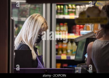 BELGRAD, SERBIEN - 22. SEPTEMBER 2020: Weibliche Angestellte, Kassiererin eines Supermarkthandels mit einer Atemmaske in Belgrad, während der Cor Stockfoto