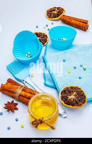 Traditionelles kulinarisches Konzept. Backzubehör, frischer Honig, duftende Gewürze und trockene Früchte. Sanfter blauer Hintergrund, Nahaufnahme Stockfoto