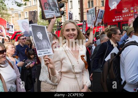 Der Londoner Marsch des Immortal Regiments, der marsch soll russischen Männern und Frauen gedenken, die im Zweiten Weltkrieg gekämpft haben und in Russland und anderen Ländern am 9. Mai im Rahmen der Feierlichkeiten zum Victory Day stattfinden. Während der Märsche tragen die Menschen Fotos ihrer Verwandten, die am Krieg teilnahmen. Etwa 12 Millionen Menschen nahmen 2015 an den Märschen des Immortal Regiments in ganz Russland Teil. Der Londoner marsch begann von der Nordterrasse des Trafalgar Square, direkt vor der National Gallery, dem 'Regiment', dann zu Fuß zum College Green über Whitehall, Downing Street, Parliament Square und West Stockfoto