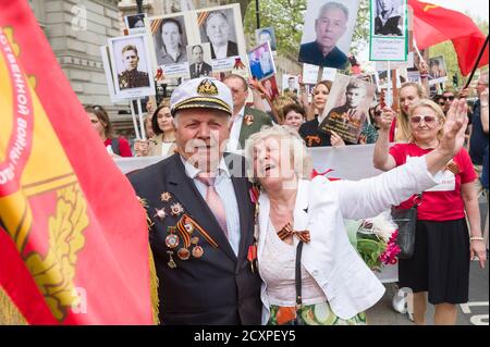 Der Londoner Marsch des Immortal Regiments, der marsch soll russischen Männern und Frauen gedenken, die im Zweiten Weltkrieg gekämpft haben und in Russland und anderen Ländern am 9. Mai im Rahmen der Feierlichkeiten zum Victory Day stattfinden. Während der Märsche tragen die Menschen Fotos ihrer Verwandten, die am Krieg teilnahmen. Etwa 12 Millionen Menschen nahmen 2015 an den Märschen des Immortal Regiments in ganz Russland Teil. Der Londoner marsch begann von der Nordterrasse des Trafalgar Square, direkt vor der National Gallery, dem 'Regiment', dann zu Fuß zum College Green über Whitehall, Downing Street, Parliament Square und West Stockfoto