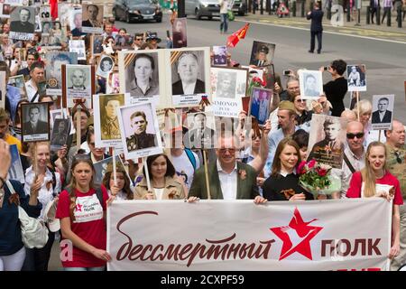 Botschafter der Russischen Föderation in Großbritannien, Alexander Wladimirowitsch Jakowenko, (grüne Jacke und Brille) führt, die London Marsch des Immortal Regiment, Der marsch soll russischen Männern und Frauen gedenken, die im Zweiten Weltkrieg gekämpft haben und in Russland und anderen Ländern am 9. Mai im Rahmen der Feier des Siegestages stattfinden. Während der Märsche tragen die Menschen Fotos ihrer Verwandten, die am Krieg teilnahmen. Etwa 12 Millionen Menschen nahmen 2015 an den Märschen des Immortal Regiments in ganz Russland Teil. Der Londoner marsch begann von der Nordterrasse des Trafalgar Square, direkt vor dem Stockfoto