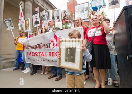 Der Londoner Marsch des Immortal Regiments, der marsch soll russischen Männern und Frauen gedenken, die im Zweiten Weltkrieg gekämpft haben und in Russland und anderen Ländern am 9. Mai im Rahmen der Feierlichkeiten zum Victory Day stattfinden. Während der Märsche tragen die Menschen Fotos ihrer Verwandten, die am Krieg teilnahmen. Etwa 12 Millionen Menschen nahmen 2015 an den Märschen des Immortal Regiments in ganz Russland Teil. Der Londoner marsch begann von der Nordterrasse des Trafalgar Square, direkt vor der National Gallery, dem 'Regiment', dann zu Fuß zum College Green über Whitehall, Downing Street, Parliament Square und West Stockfoto