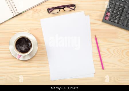 Notizblock, Kaffeetasse, grüne Topfpflanze, Bürobedarf auf Holztisch, Draufsicht, Kopierraum. Arbeitsraum eines Geschäftsmannes. Blick von oben. Stockfoto
