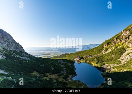 Velicke pleso See mit Sliezsky Hotel auf Velicka dolina Tal In Vysoke Tatry Berge in der Slowakei während schönen Morgen mit Der Himmel ist klar Stockfoto