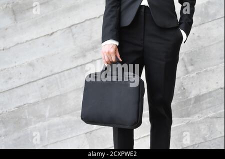 Mann in Business Anzug stehend mit Aktentasche Anfang des Arbeitstages. Hochwertige Fotos Stockfoto