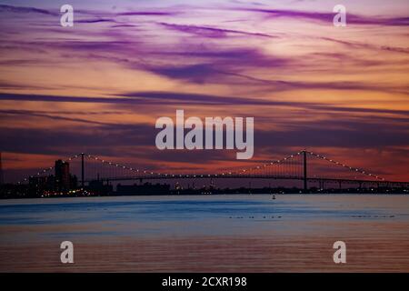 Nachtansicht des Ambassador Bridge Panoramas über Detroit River und Stadt am sonnigen Tag von Sonnenuntergang Punkt der Belle Isle Stockfoto