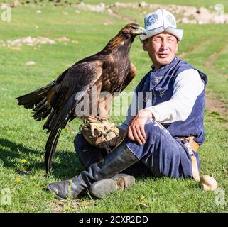 Issyk Kul, Kirgisistan - Mai 28, 2017 - Adler Jäger hält sich die Adler auf dem Arm vor der Jagd Stockfoto