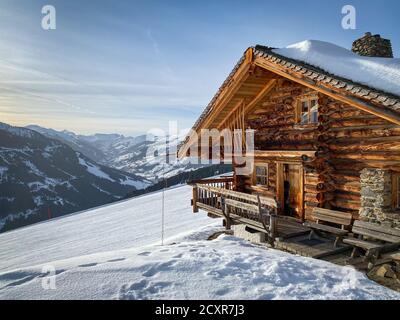 Verschneite Berghütte altes Bauernhaus im Skigebiet Von Saalbach Hinterglemm in den österreichischen alpen gegen Himmel Stockfoto