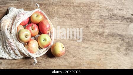 Bio-Äpfel in wiederverwendbarer umweltfreundlicher Netztasche auf dem Holzhintergrund. Zero Waste Konzept und Kunststoff frei Lebensstil. Draufsicht, Kopierbereich Stockfoto