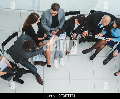 Ansicht von oben. Bild eines Geschäftsteams, das Geschäftsdokumente diskutiert Stockfoto