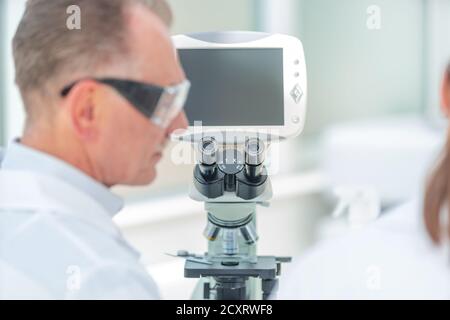 Nahaufnahme. Ein Mediziner sitzt an einem Labortisch. Stockfoto