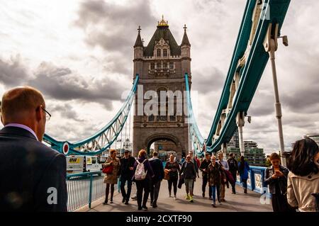 London, Großbritannien - 14. September 2017: Einheimische und Touristen überqueren die Themse durch die berühmte Tower Bridge mit ihrem lebhaften azurblauen han Stockfoto