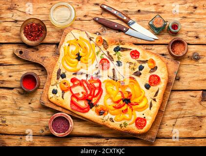 Hausgemachte italienische Focaccia mit Paprika, Tomaten, Basilikum und Oliven. Stockfoto