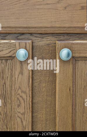 Braune Schranktüren aus Holz mit silbernen Griffen, Farbmuster aus Holz im vertikalen Format. Stockfoto