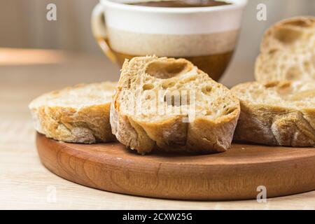 Brotscheiben und eine Tasse Kaffee auf einem Holz Tisch mit Tisch und Bettwäsche Stockfoto