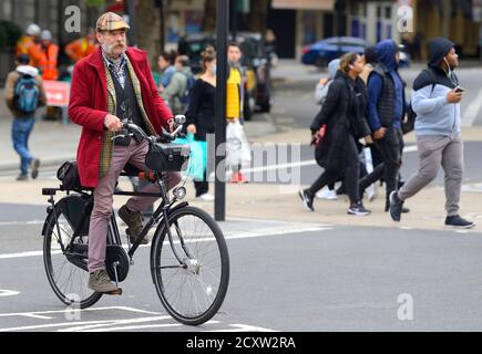 London, England, Großbritannien. Interessanterweise gekleideter Mann beim Radfahren in The Strand Stockfoto