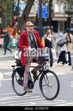 London, England, Großbritannien. Interessanterweise gekleideter Mann beim Radfahren in The Strand Stockfoto