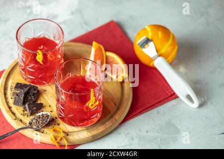 Zwei Gläser Schokolade rote Orange negroni, alkoholische bittere Cocktail von Zutaten auf dem hellgrauen Tisch serviert. Stockfoto