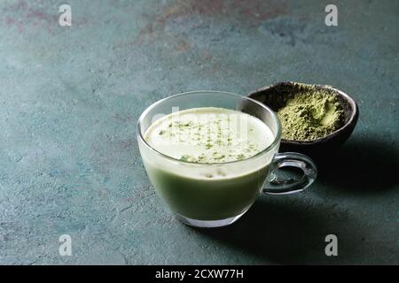 Tasse Matcha Latte mit Schale Matcha Tee über Grau Grün Textur Hintergrund. Kopieren Sie Platz. Stockfoto