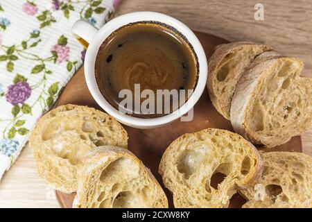 Brotscheiben und eine Tasse Kaffee auf einem Holz Tisch mit Tisch und Bettwäsche Stockfoto