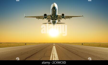Das Verkehrsflugzeug hebt gegen einen Sonnenuntergang ab Stockfoto